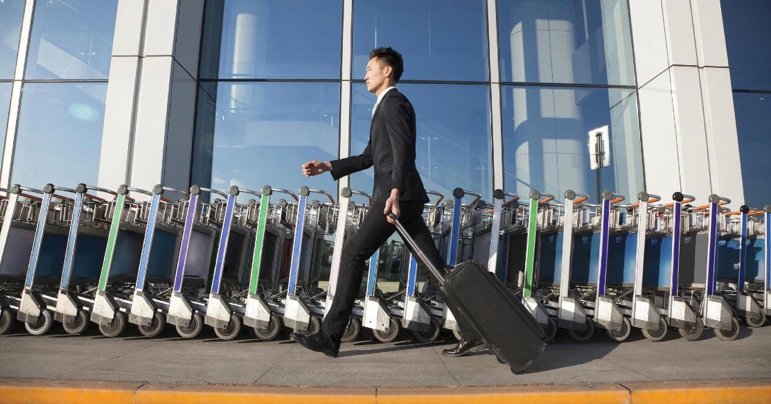 原策略稿人群情境图：旅客拖着行李走过航站楼